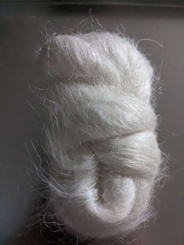 Bundle of nettle fibre. It is bright white, wrapped around itself, with small fibres visible